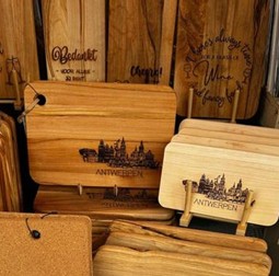 Houten tapasplanken met gegraveerd logo op een gedekte tafel